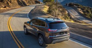 Grey 2020 Jeep Cherokee driving down a winding road