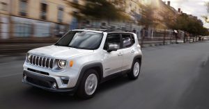 White 2020 Jeep Renegade driving down a city street