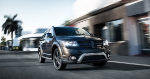 a black 2020 Dodge Journey driving down a city street 
